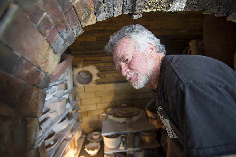 Professor Randy Johnston tends to the wood-fired kiln