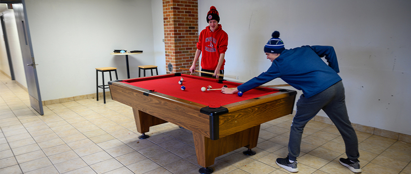 Two students shoot pool in the Crabtree basement