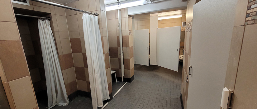 May hall bathroom includes multiple sinks, shower stalls, toilet stalls, mirrors and sinks