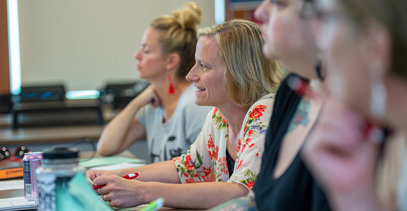 women engage in conversation while sitting at a table