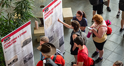 A group of faculty members view banners detailing UWRF history during Opening Meeting