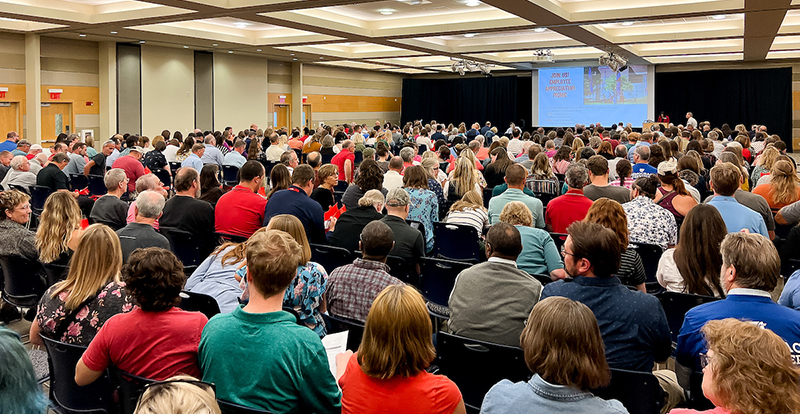 crowd of people sitting in a large meeting room