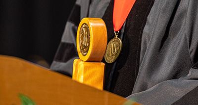 A medal hangs around the neck of a dean during commencement
