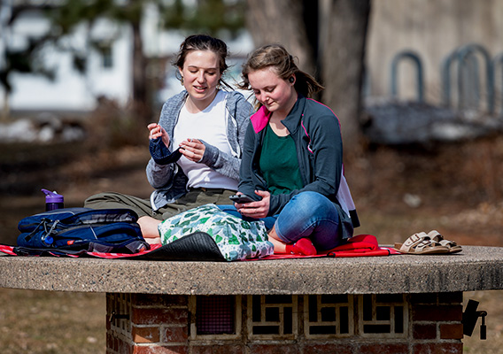Two students enjoy the weather outside