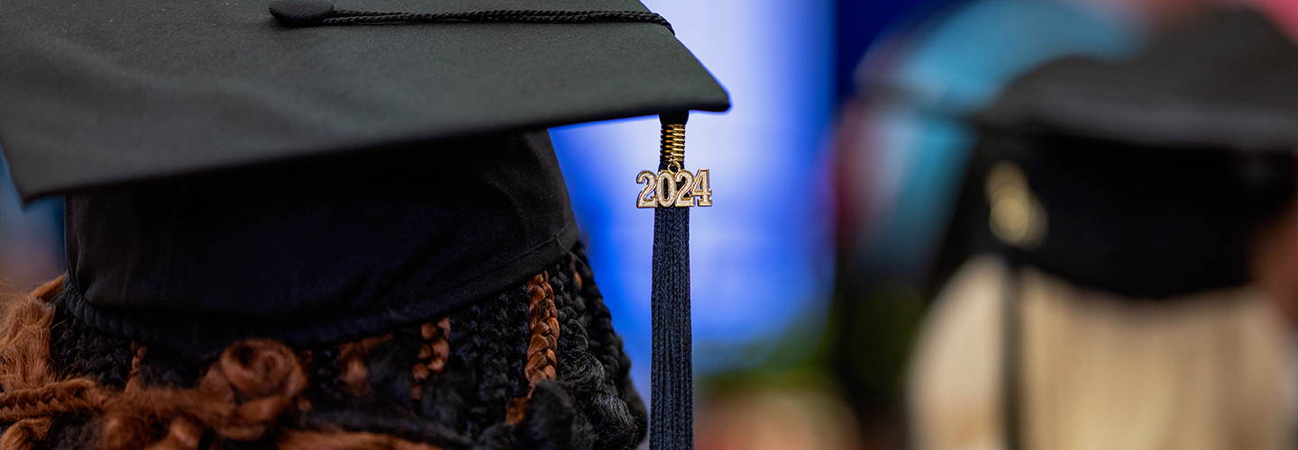 A student watches a speaker at the podium during the 2024 Commencement ceremony. 